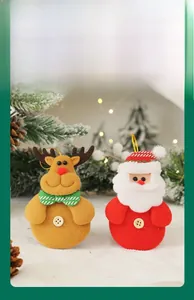 Close-up of reindeer and Santa Claus plush ornaments with gold hanging strings