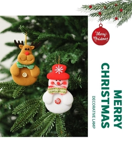 Detail of plush reindeer and snowman Christmas tree ornaments with decorative button accents