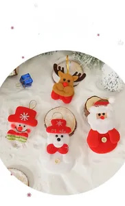 Close-up of 4 plush Christmas ornaments including Santa and Reindeer on artificial snow