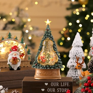 Detailopname van de verlichte kerstboom sneeuwbol met kerstman en gouden versierde voet