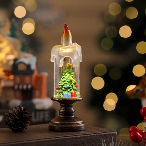 Close-up of LED Christmas candle lamp with miniature tree and melting wax detail