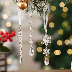 Detailed view of clear icicle and snowflake ornaments hanging on a Christmas tree branch
