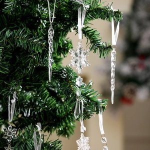 Close-up of clear acrylic icicle and snowflake ornaments hanging on a Christmas tree