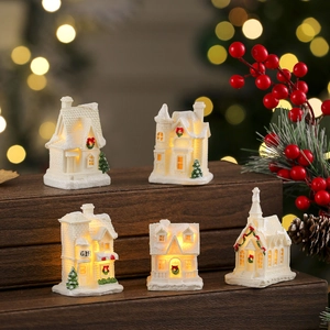 Set of five white resin Christmas village houses with warm LED lights and snowy roofs