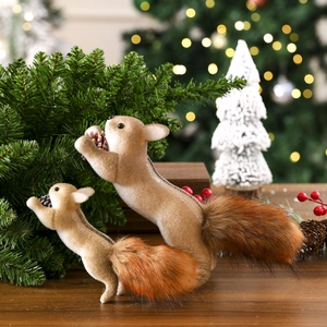 Detail of two festive squirrel ornaments with soft fur and bushy tails on a wooden table