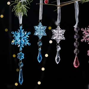 Sparkling acrylic snowflake ornaments with prism drops hanging on a Christmas tree branch