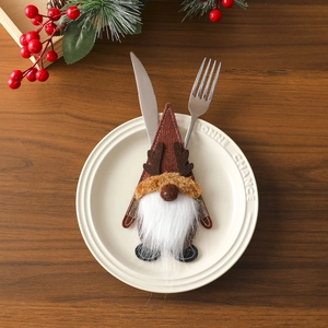 Close-up of gnome silverware holder with reindeer antlers on a white plate