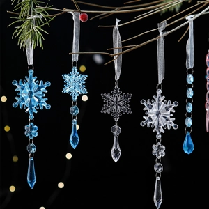 Set of 5 clear and blue acrylic snowflake ornaments hanging on Christmas tree branches