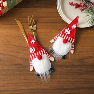 Christmas gnome cutlery holder set with red felt hats on wood table setting