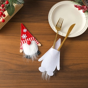 Detail of Christmas gnome cutlery holders with red felt and festive stripes on table