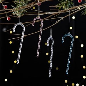 Detailed view of clear acrylic candy cane ornaments with spiral texture on festive branches