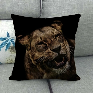 Detailed close-up of a roaring lion print on a square black linen pillowcase on sofa