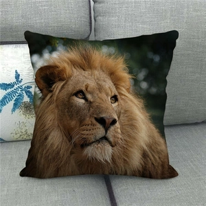 Close-up of realistic lion head print on soft linen pillowcase on a grey sofa