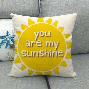 Linen square pillow cover with You Are My Sunshine sun print on a gray sofa