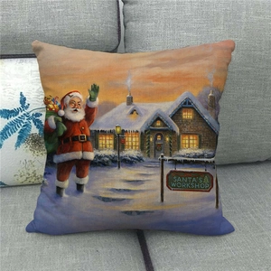Detail of linen Christmas pillowcase with Santa Claus and workshop print on a gray sofa