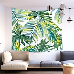 Detail view of the tropical monstera leaf tapestry hanging in a modern living room setting
