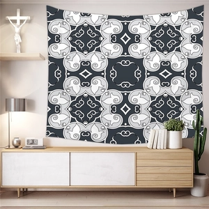 Bohemian black and white geometric mandala tapestry hanging in a cozy living room scene