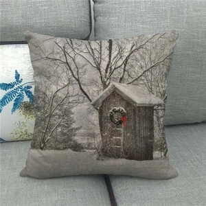 Detail of linen pillowcase featuring a rustic snow cabin with a Christmas wreath