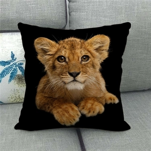 Detailed view of square black linen pillowcase with realistic lion cub print on a sofa