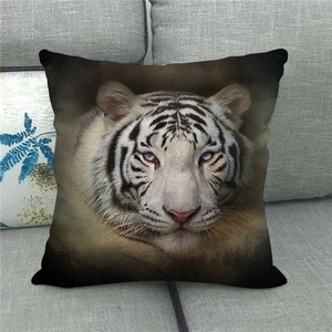 Detail of linen pillowcase featuring a realistic white tiger face on a grey fabric sofa