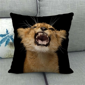 Detail of linen pillowcase with a vivid lion cub roar print on a grey fabric sofa
