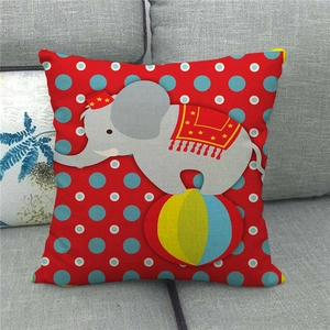 Detailed close-up of a red linen pillow case featuring a circus elephant print on a sofa