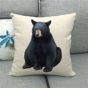 Detailed texture of linen pillowcase with realistic black bear print on grey sofa