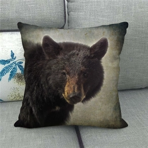 Detailed close-up of a rustic black bear portrait printed on a linen square pillowcase