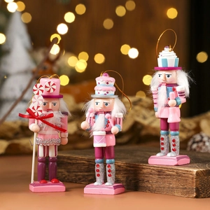 Detailed trio of pink nutcracker wooden ornaments with glitter accents and hanging gold cords