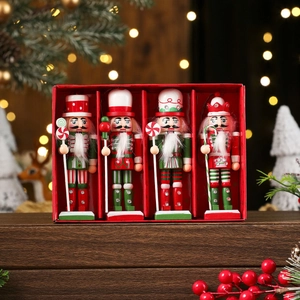 Close-up of four wooden nutcracker soldiers with candy canes in a red gift display box