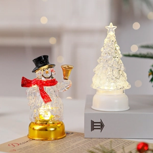Gros plan d'un bonhomme de neige et d'un sapin de Noël LED lumineux sur une table en bois