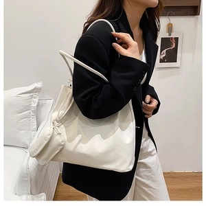 Detailed view of a white minimalist oversized suede tote bag with matching mini pouch