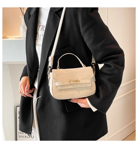 Détail du mini sac à main blanc crème avec fermoir doré rotatif et texture fine