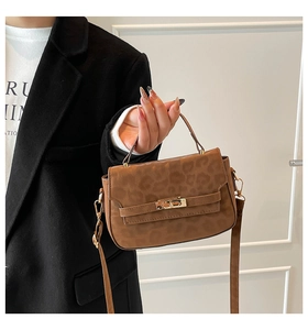Gros plan du sac à main vintage léopard avec boucle dorée et texture mate élégante