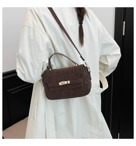 Detail of leopard print crossbody bag with golden lock on white trench coat