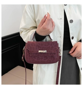 Detail of burgundy leopard print handbag with metallic clasp and suede texture