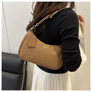 Detailansicht der braunen Hobo-Tasche mit Webmuster, Goldkette und Lederbesatz