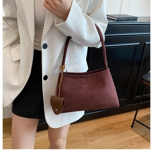 Burgundy faux suede shoulder bag with brown leather mini pouch detail worn by a model