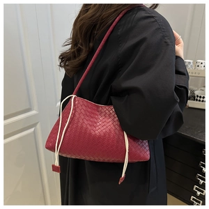 Vista dettagliata della borsa a spalla intrecciata rossa con coulisse bianca laterale