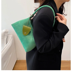 Detail view of premium green faux suede underarm bag with decorative mini pouch attachment