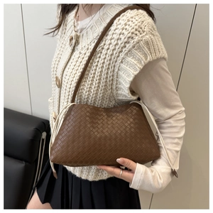 Dettaglio della borsa a tracolla in pelle intrecciata marrone scuro con texture