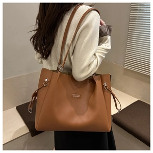 Detalle del bolso tote camel grande con textura mate y cordones decorativos laterales