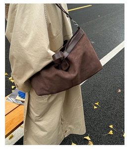Detail of dark brown matte tote bag showing suede texture and polished leather splicing