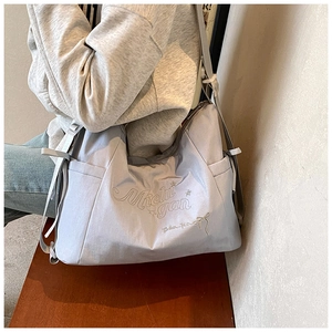 Détail du sac fourre-tout en nylon gris clair avec broderie Michigan et poche latérale