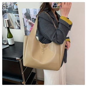 Close-up of the elegant golden metal clasp on this large khaki leather tote bag
