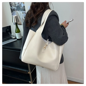 Detail of minimalist cream-white tote bag with wide shoulder strap and metal hook buckle