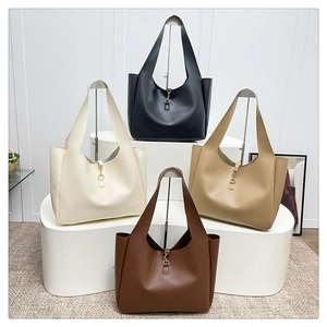 Detail view of large leather tote bags in four neutral colors with metal hook closure