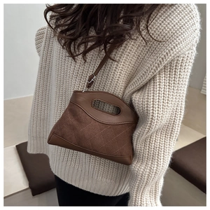 Close-up of brown quilted patchwork shoulder bag with sleek leather and fabric texture