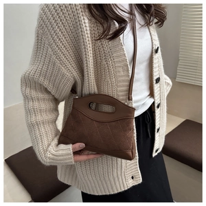 Detail of vintage brown suede and leather crossbody bag with elegant diamond stitching