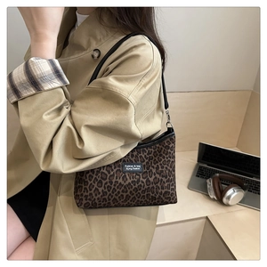 Detail of trendy leopard print tote bag on shoulder with fashion label and black strap